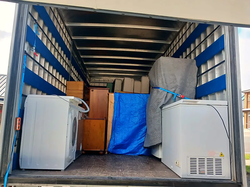 Truck interior packed with appliances and furniture, secured for transit
